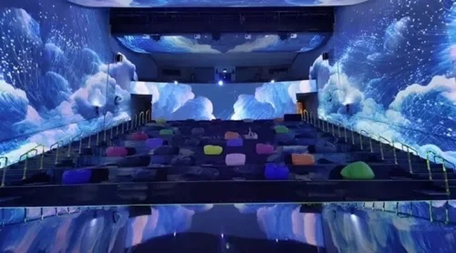 Blue clouds projected across an immersive theatre